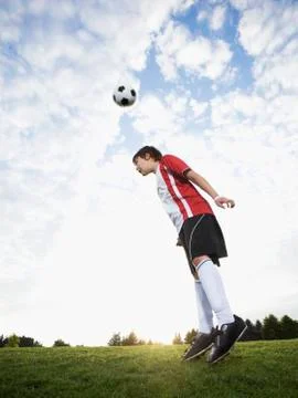 Boy in uniform bouncing soccer ball off head Stock Photos