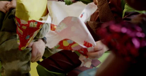 Boy unwrapping a gift in classroom Stock Footage 58573964