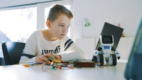 Boy uses a laptop computer and looks concentrated at the screen Stock Footage 102176434