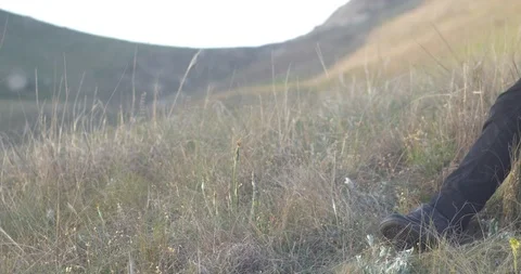 A boy uses a mobile phone while sitting on a rock in the nature Video stock 90804656