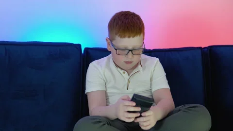 Boy uses old controller to play video game. A boy plays old 8 bit game. Cozy Stock Footage 194727057