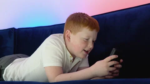 Boy uses old controller to play video game. A boy plays old 8 bit game. Cozy Stock Footage 194727723