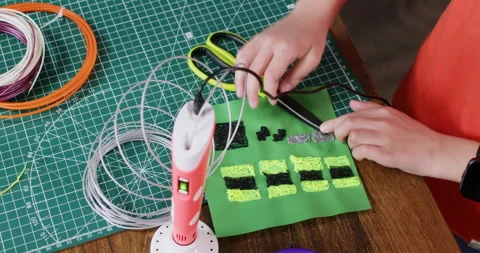 Boy uses scissors to shape plastic details made with 3d pen Stock Footage 322007632