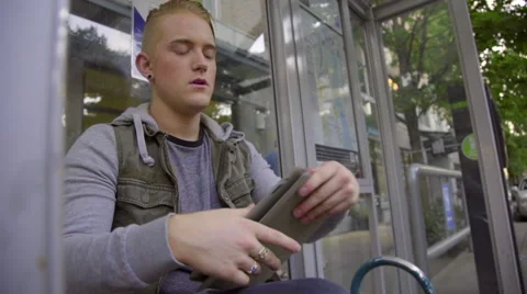 Boy uses tablet computer at bus station Stock Footage 54092430