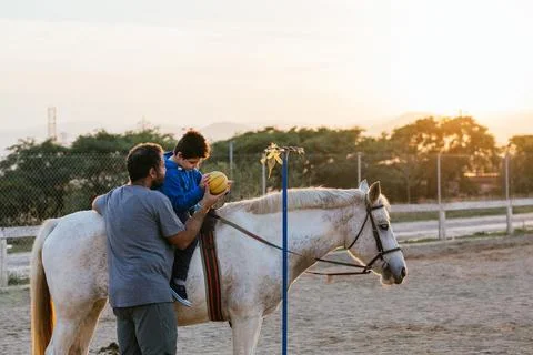 Boy using a ball during an equine therapy session Stock Photos