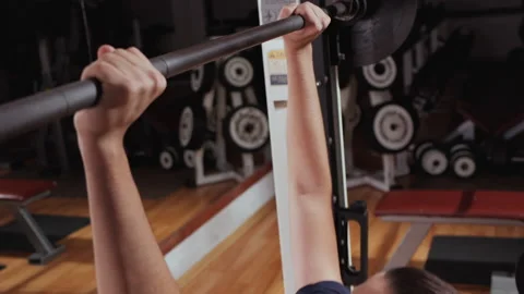 Boy using bench chest press machine in gym - close up Video stock 152776391