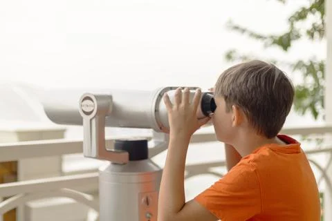 Boy using binocular viewer on balcony Stock Photos