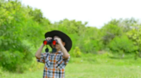 Boy using binoculars in garden Stock Footage 53045201