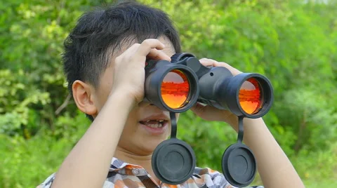 Boy using binoculars in garden Stock Footage 53050247