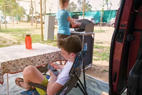 Boy using cellphone while waiting for lunch Stock Photos