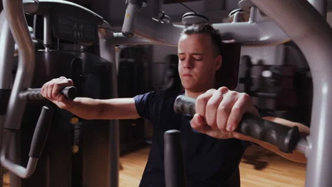 Boy using chest press machine in gym - close up Video stock 152776364