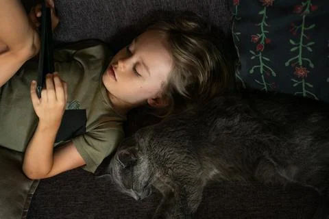 Boy using digital tablet computer playing games or watching cartoons at home. Stock Photos