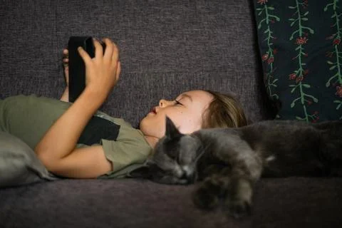 Boy using digital tablet computer playing games or watching cartoons at home. Stock Photos