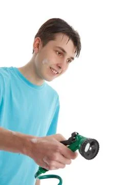 Boy using a garden hose Stock Photos
