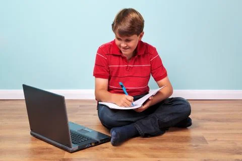 Boy using his laptop for homework Stock Photos