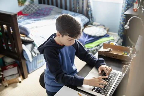 Boy using laptop in bedroom high angle view Stock Photos