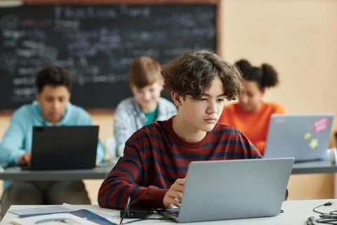 Boy using laptop computer in class during programming lesson Stock Photos
