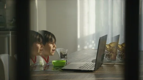 Boy using laptop at dining table in home Stock Footage 119992666