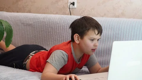 Boy using a laptop playing online games blogging, studying online 库存影片 148630640