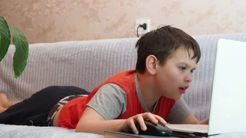 Boy using a laptop playing online games blogging, studying online 库存影片 148630740
