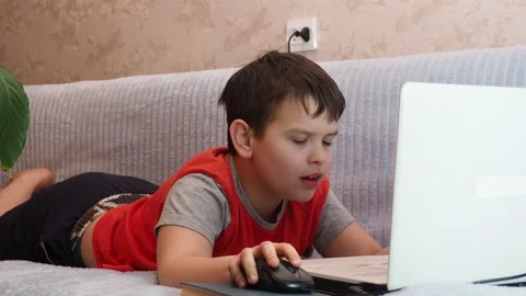 Boy using a laptop playing online games blogging, studying online 库存影片 148630754