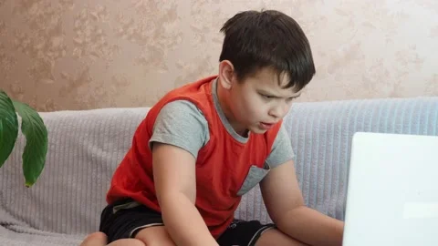 Boy using a laptop playing online games blogging, studying online 库存影片 148630809