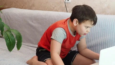Boy using a laptop playing online games blogging, studying online 库存影片 148630842