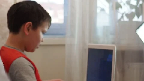 Boy using a laptop playing online games blogging, studying online 库存影片 148630926