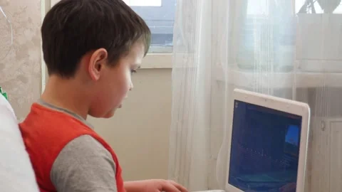 Boy using a laptop playing online games blogging, studying online 库存影片 148630927