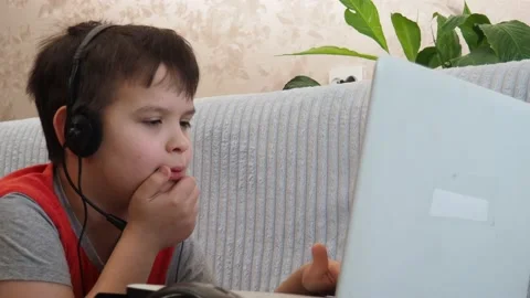 Boy using a laptop playing online games or tablet communicate blogging, studying Видео 148631781