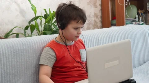Boy using a laptop playing online games or tablet communicate blogging, studying Vidéo 148631888