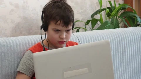 Boy using a laptop playing online games or tablet communicate blogging, studying Vidéo 148632125
