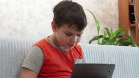 Boy using a laptop playing online games or tablet communicate blogging, studying Stockbeeldmateriaal 148632585