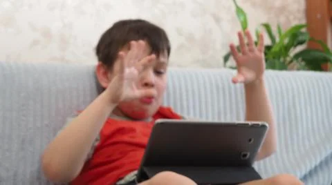 Boy using a laptop for playing online games and wearing headphone at home, a  Stock Photos