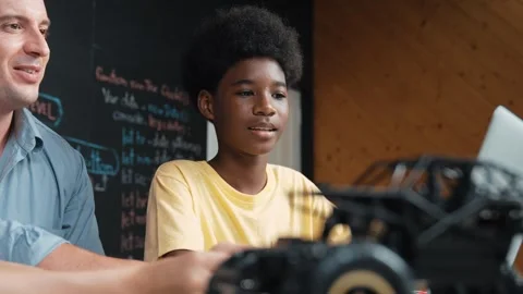 Boy using laptop to program code or prompt with car model placed. Edification Stock Footage 267611035