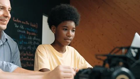 Boy using laptop to program code or prompt with car model placed. Edification. Photos
