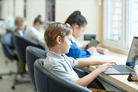 Boy using Laptop in School in It Class For Children Stock Photos