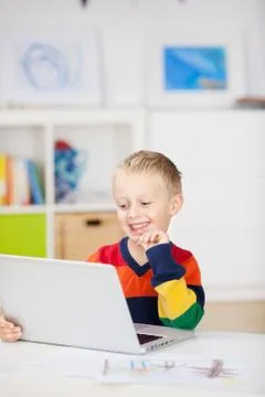 Boy using laptop at table in house Stock Photos