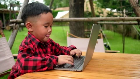 Boy using laptop while attending the online classes in garden. Stock Footage 206076087