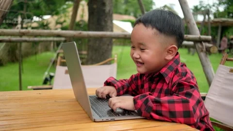 Boy using laptop while attending the online classes in garden. Stock Footage 206076398
