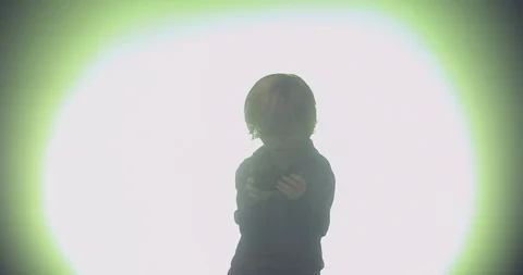 Boy using mobile phone against illuminated background Stock Footage 99989460