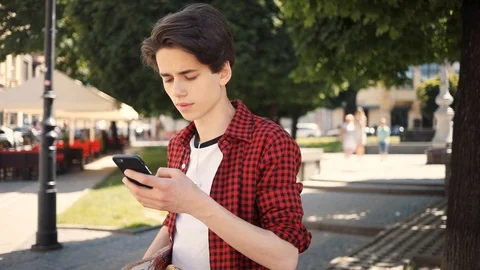 Boy using a mobile phone walk keeps skate guy business fashion hand child sun Video stock 92050974