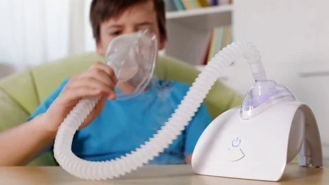 Boy using nebuliser inhaler with mask - rack focus, static camera Video stock 80145012