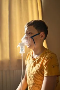 Boy using a nebulizer inhaler at home. Stock Photos