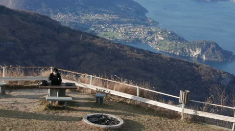 Boy using a PC in the mountains overlooking the lake Stock Footage 59526314