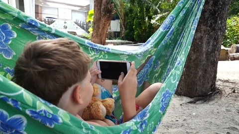 Boy using phone in hammock Stock-Footage 115122965