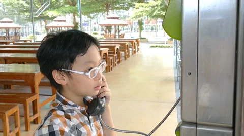 Boy using public phone Stock Footage 64531319