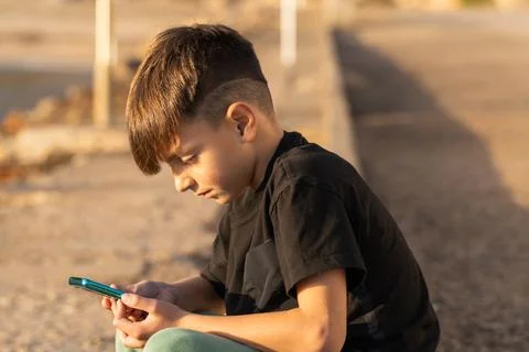 Boy using smartphone on beach Stock Photos
