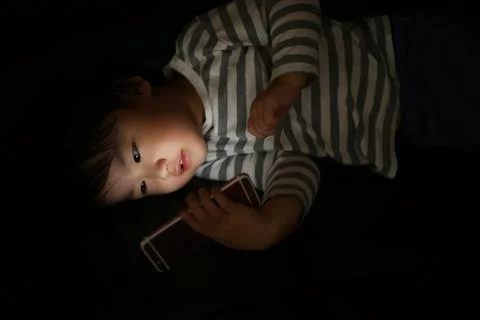 Boy using smartphone in the dark Stock Photos