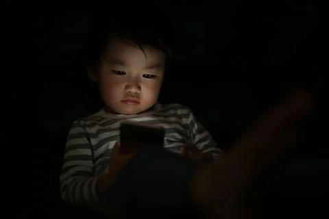 Boy using smartphone in the dark Stock Photos